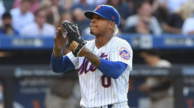 Mets starting pitcher Marcus Stroman reacts as he walks to...