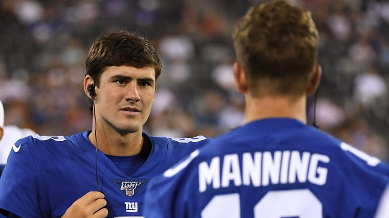 Giants quarterback Daniel Jones talks to quarterback Eli Manning on...