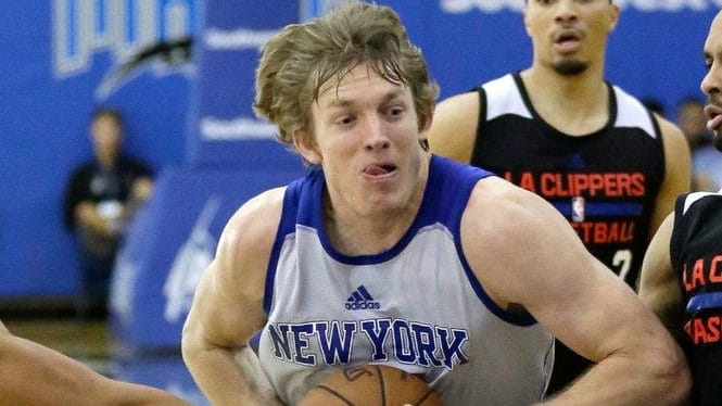 New York Knick's Ron Baker, center, drives between Los Angeles...