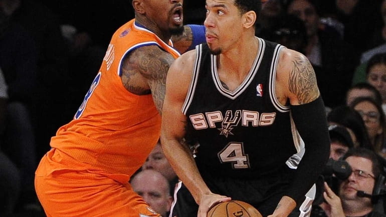 Knicks guard J.R. Smith defends against San Antonio Spurs guard...