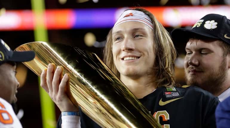 Clemson's Trevor Lawrence holds the trophy after the NCAA college...