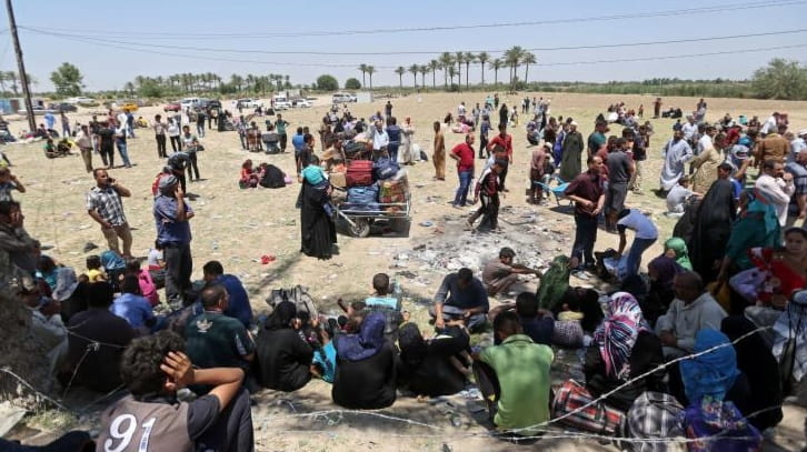 Displaced Iraqis from Ramadi rest before crossing the Bzebiz bridge...
