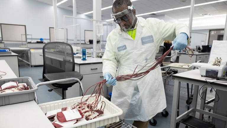 A worker at New York Blood Center’s Long Island City facility...