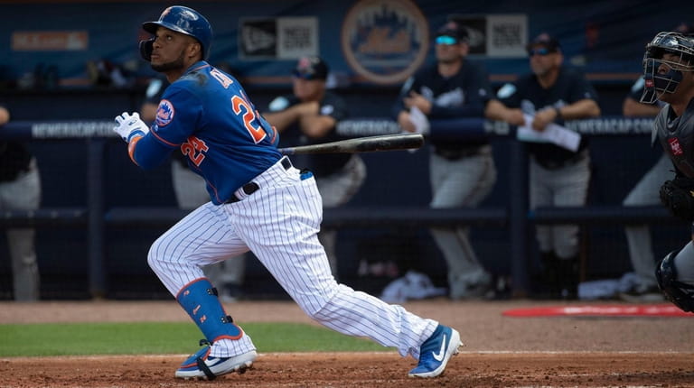 The Mets' Robinson Cano swings during a spring training game...
