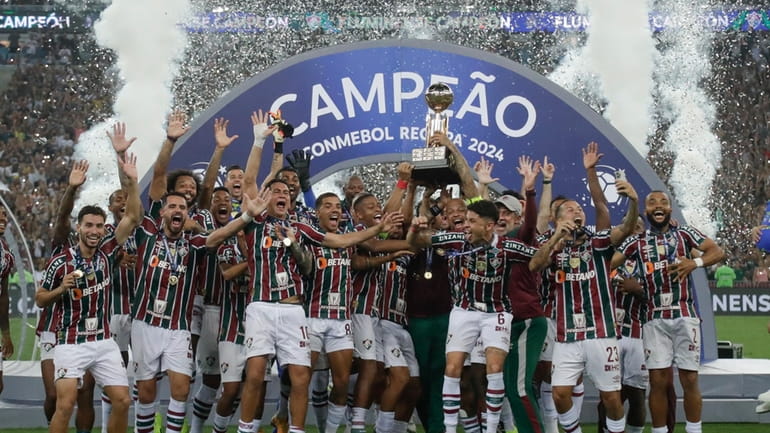 Players of Brazil's Fluminense celebrate with the trophy after winning...