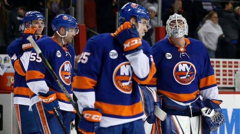 Robin Lehner of the Islanders skates off the ice with...