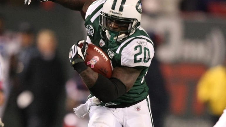Thomas Jones #20 of The New York Jets runs with...