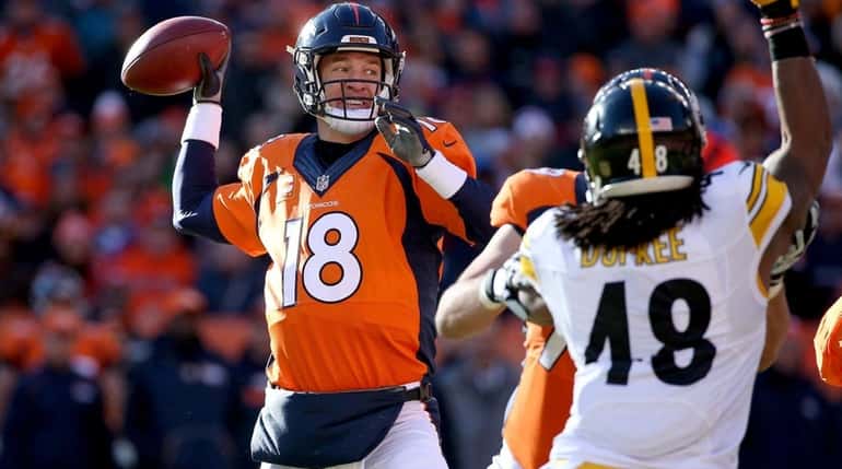 Peyton Manning of the Denver Broncos throws a pass in...
