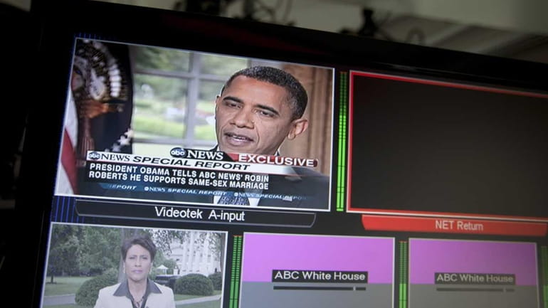 President Barack Obama is seen on television monitors in the...