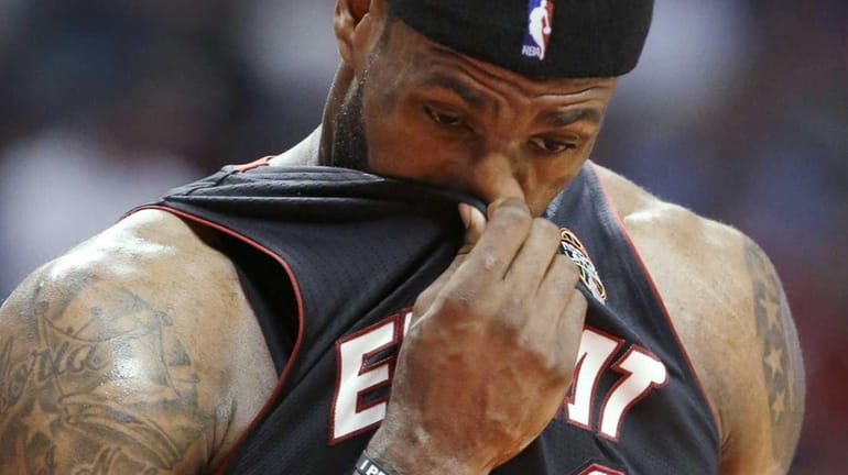 Miami Heat forward LeBron James wipes his face during the...