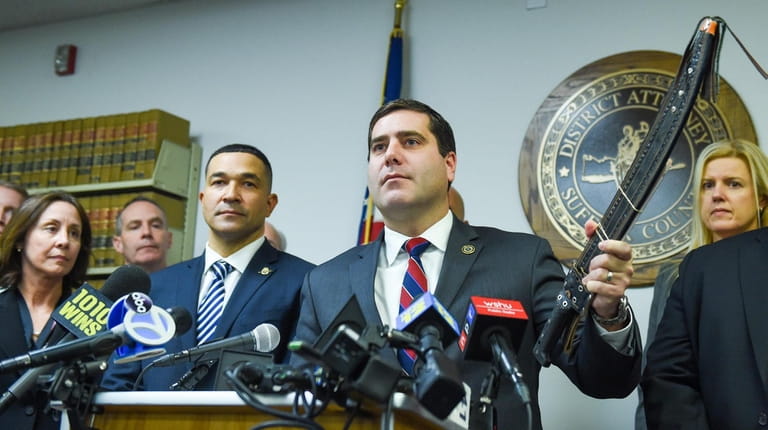 Suffolk County District Attorney Timothy Sini holds up a seized machete during...