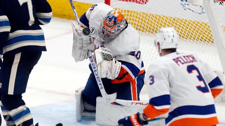 New York Islanders goalie Semyon Varlamov stops a shot between Columbus...