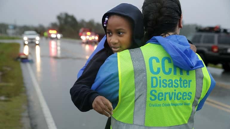 A volunteer from the Civilian Crisis Response Team carries 7-year-old...