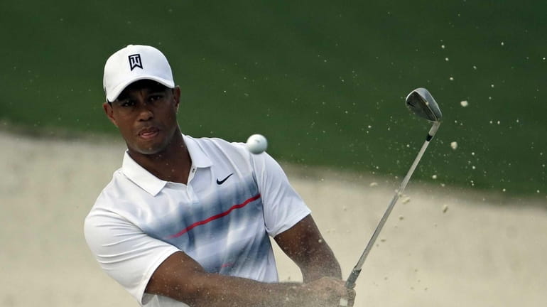 Tiger Woods hits out of a bunker at the 10th...
