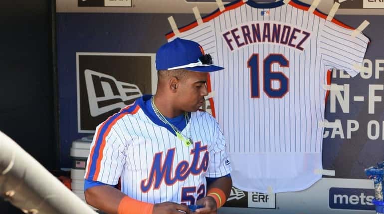 New York Mets' Yoenis Cespedes stands by a jersey remembering...