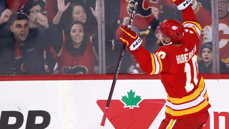 Calgary Flames' Jonathan Huberdeau and fans celebrate after his goal...