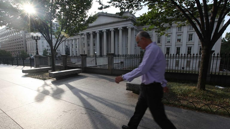 A pedestrian passes in front of the closed U.S. Treasury...