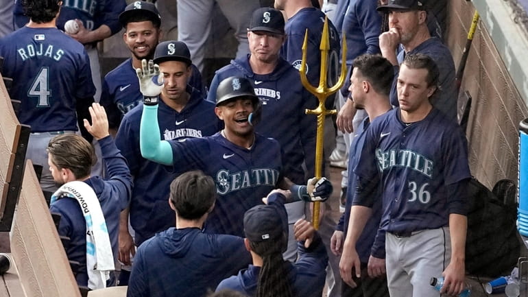 Seattle Mariners' Julio Rodriguez holds a trident in the dugout...