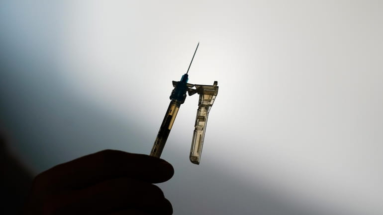 A syringe is prepared at a clinic in Norristown, Pa.,...