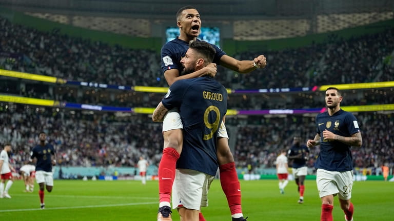 France's Olivier Giroud celebrates with France's Kylian Mbappe, after scoring...