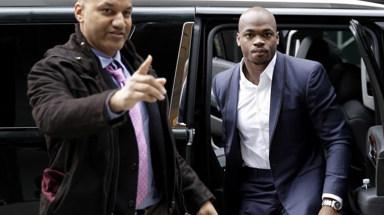 Minnesota Vikings' Adrian Peterson, right, arrives for a hearing for...