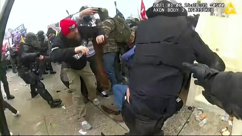 The view from a police-worn body camera shows rioters storming...