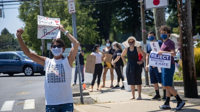 Amy Landy, of Syosset, and other protesters rally at the intersection of...