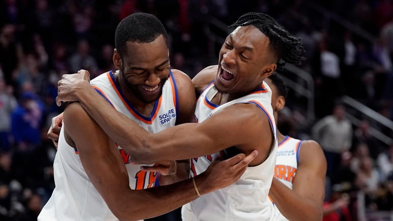Knicks guard Alec Burks, left, is hugged by teammate Immanuel...