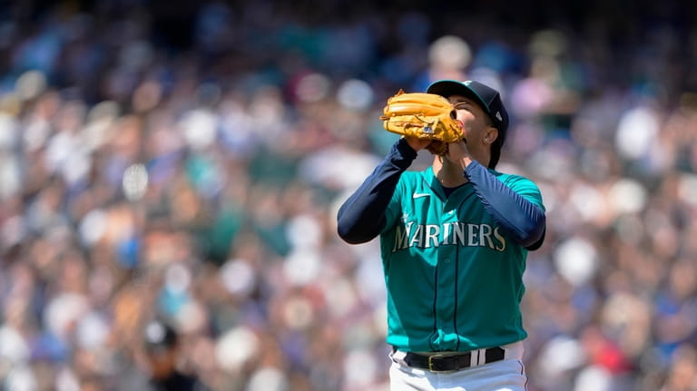 Seattle Mariners starting pitcher Luis Castillo reacts after getting through...