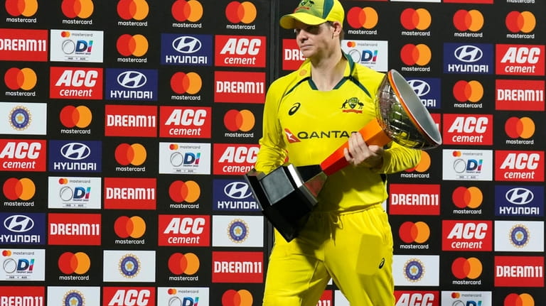 Australia's captain Steven Smith walks with the winners trophy after...