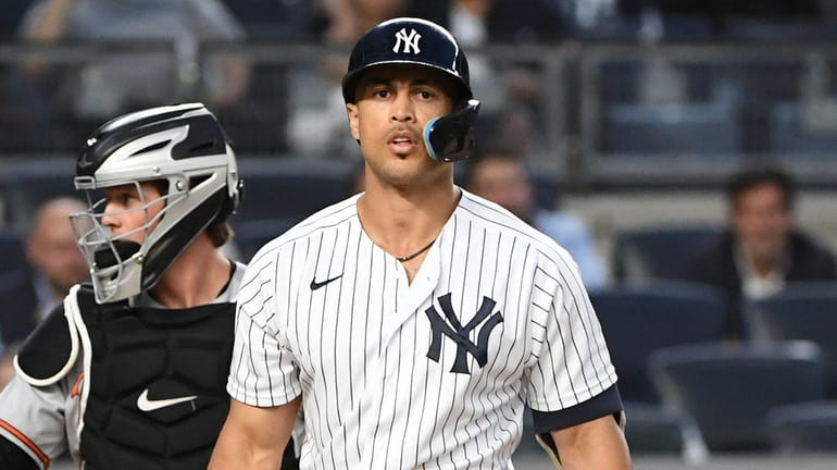 Yankees designated hitter Giancarlo Stanton reacts after he struck out...