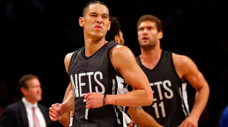 Jeremy Lin, front, of the Brooklyn Nets reacts against the...