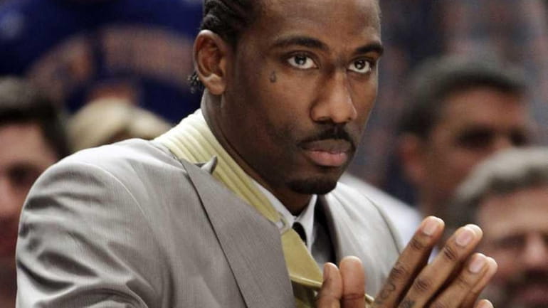 Amare Stoudemire watches from the baseline with his arm in...