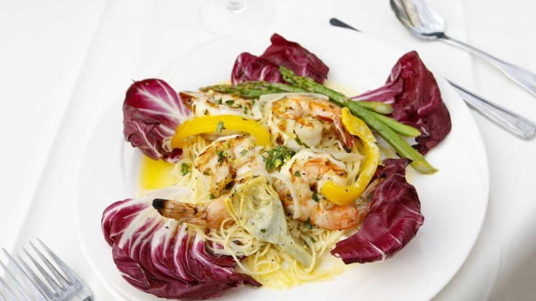 Gamberi alla griglia, grilled shrimp, is served with asparagus and...
