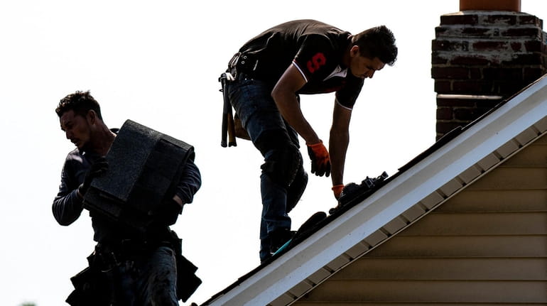 Crews work on a roof on a Roosevelt home Tuesday....