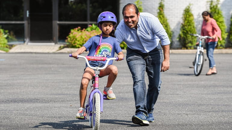Anya Shah, 7, of Woodbury, learns to ride a bicycle...