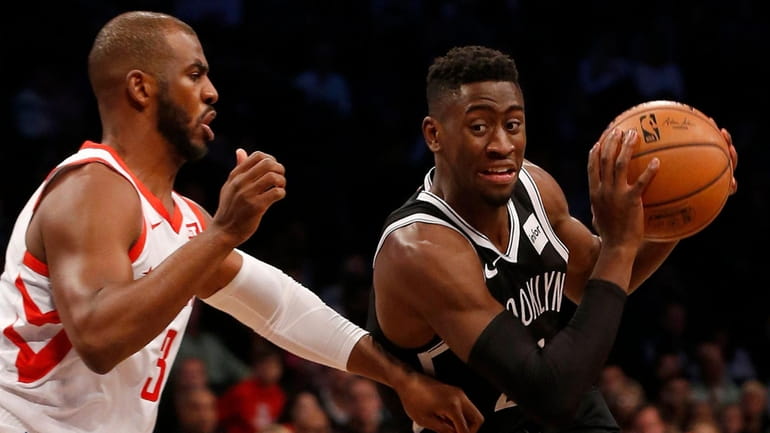 Caris LeVert of the Nets drives against Chris Paul of...