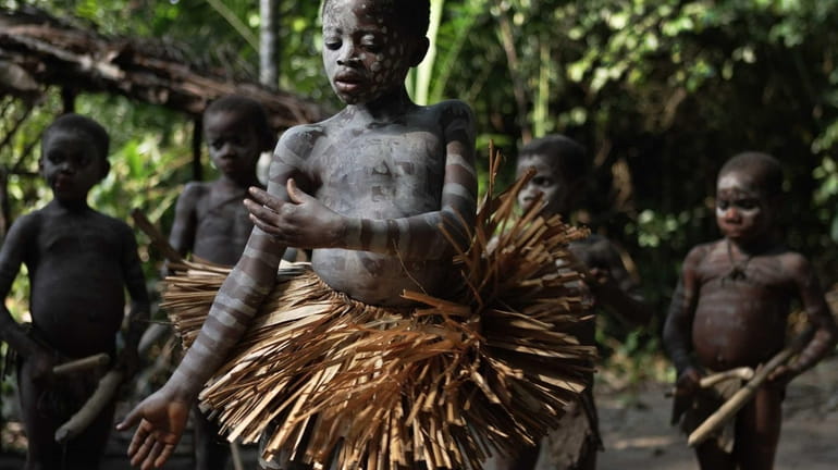 A Mbuti Pygmy boy participates in manhood initiation rites. Can...