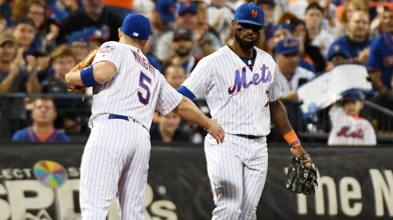 Mets third baseman David Wright gets a low five from...