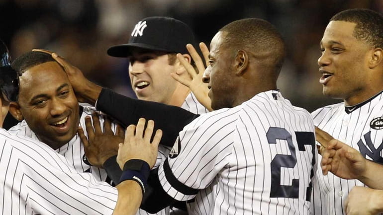 Happy teammates celebrate with New York Yankees Juan Miranda, far...