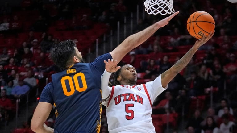 Utah guard Deivon Smith (5) goes to the basket as...
