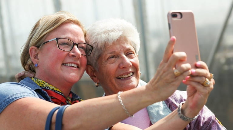 Kitty Liell of Bloomington, IN, left, snaps a self-portrait with...