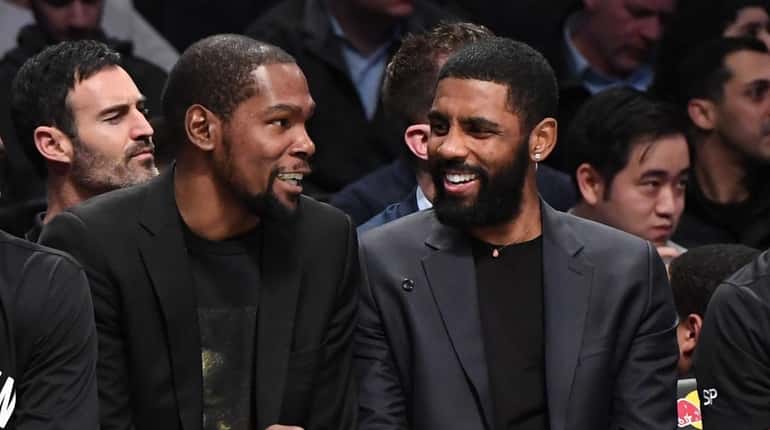 The Nets' Kevin Durant, left, and Kyrie Irving talk on the...
