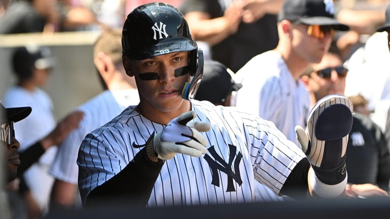 The Yankees' Aaron Judge gestures in the dugout after he...
