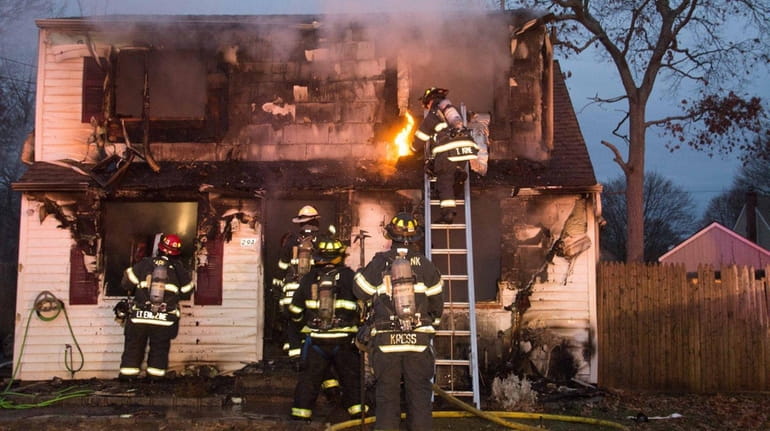 Firefighters at scene of fire in Shirley Friday, Dec. 22,...