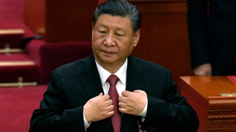 Chinese President Xi Jinping adjusts his jacket during the closing...