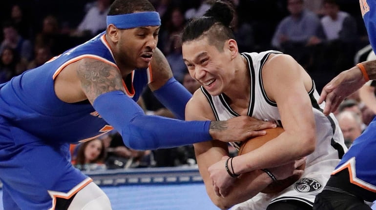 The Nets' Jeremy Lin plays keepaway from the Knicks' Carmelo...