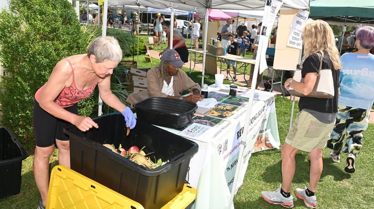 Gloria Frazee, left, and Len Green run a compost collection stand...