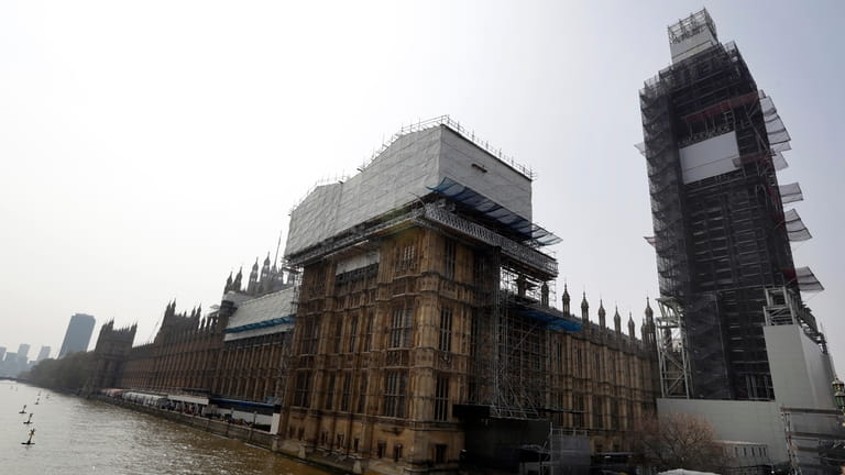Britain's Houses of Parliament, covered in hoarding and scaffolding as...