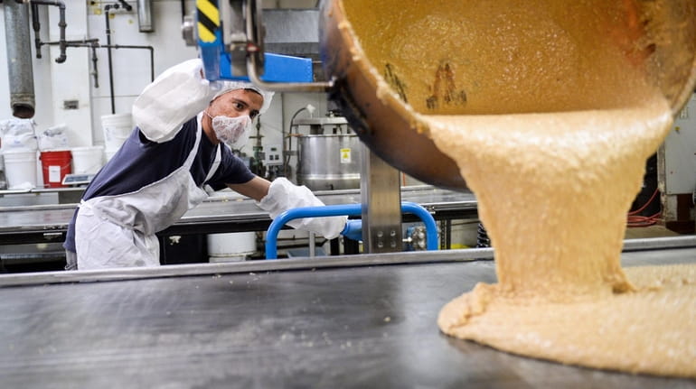 An employee pours English toffee inside the Nassau Candy factory...